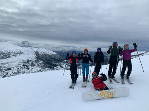 5 elevar på slalom og ein som ligg på bakken med snowboard. 