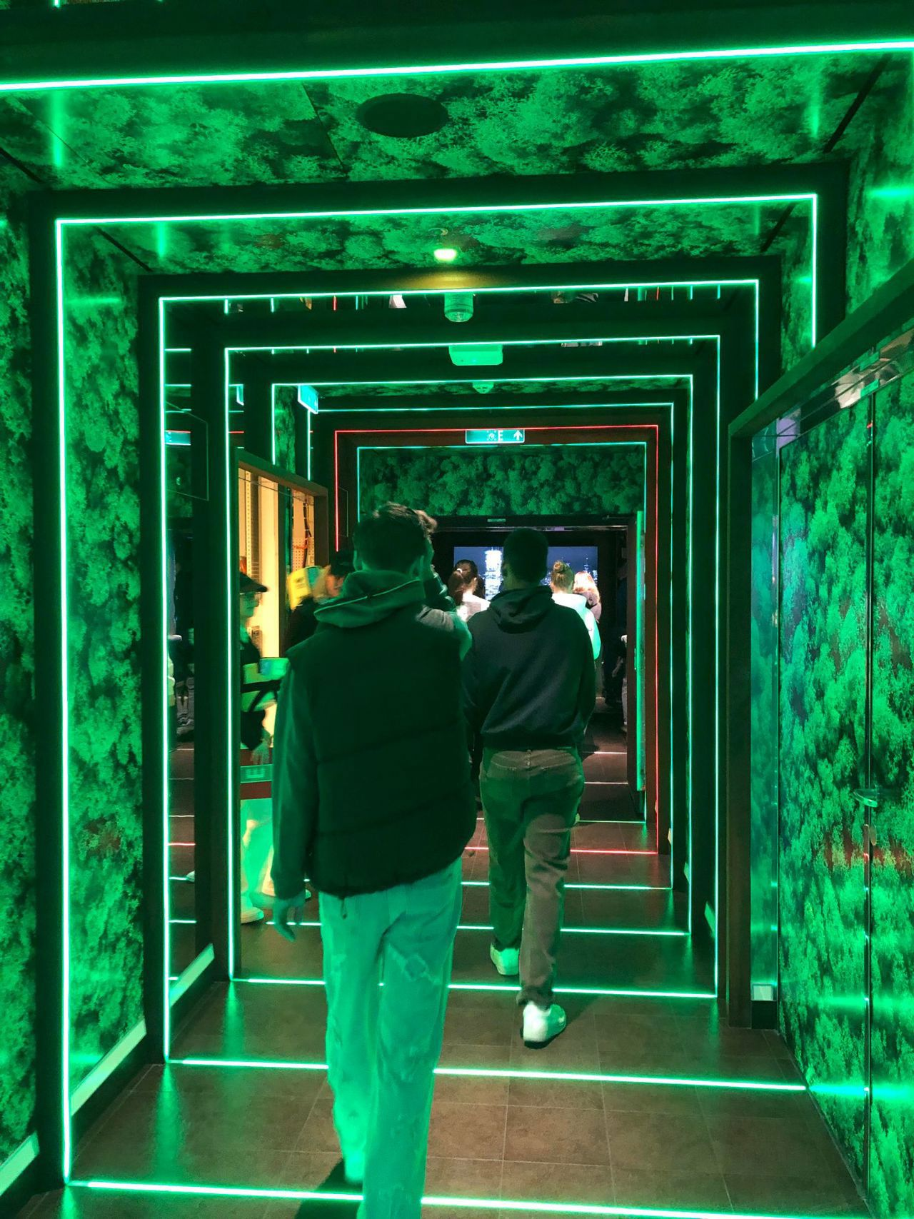 Ser ryggen på to elevar som går i det som blir kalla Green Cube ombord skipet.