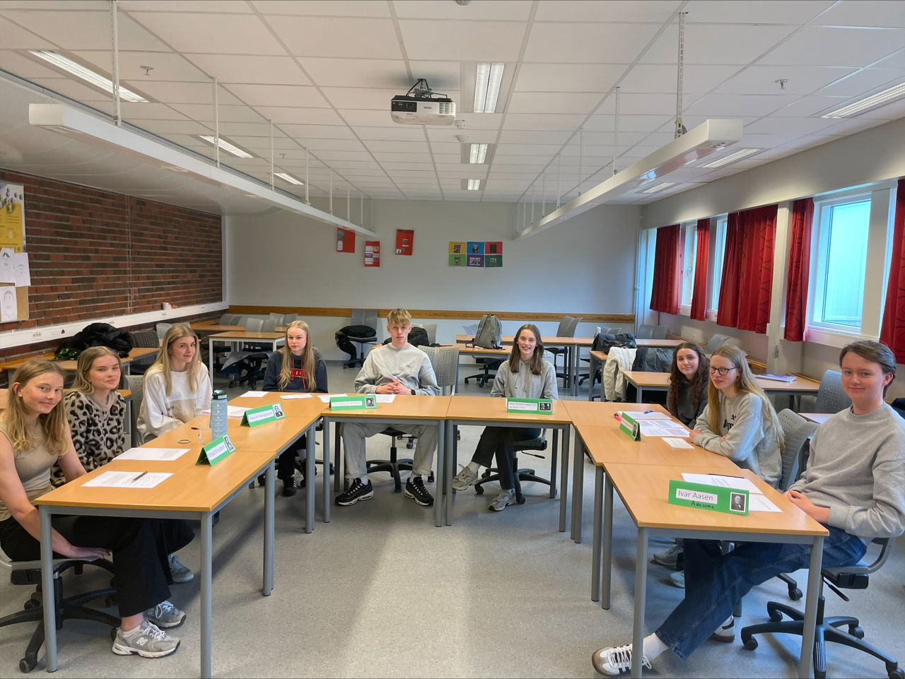 Elevar sit klare med pultane sine i klasserommet.