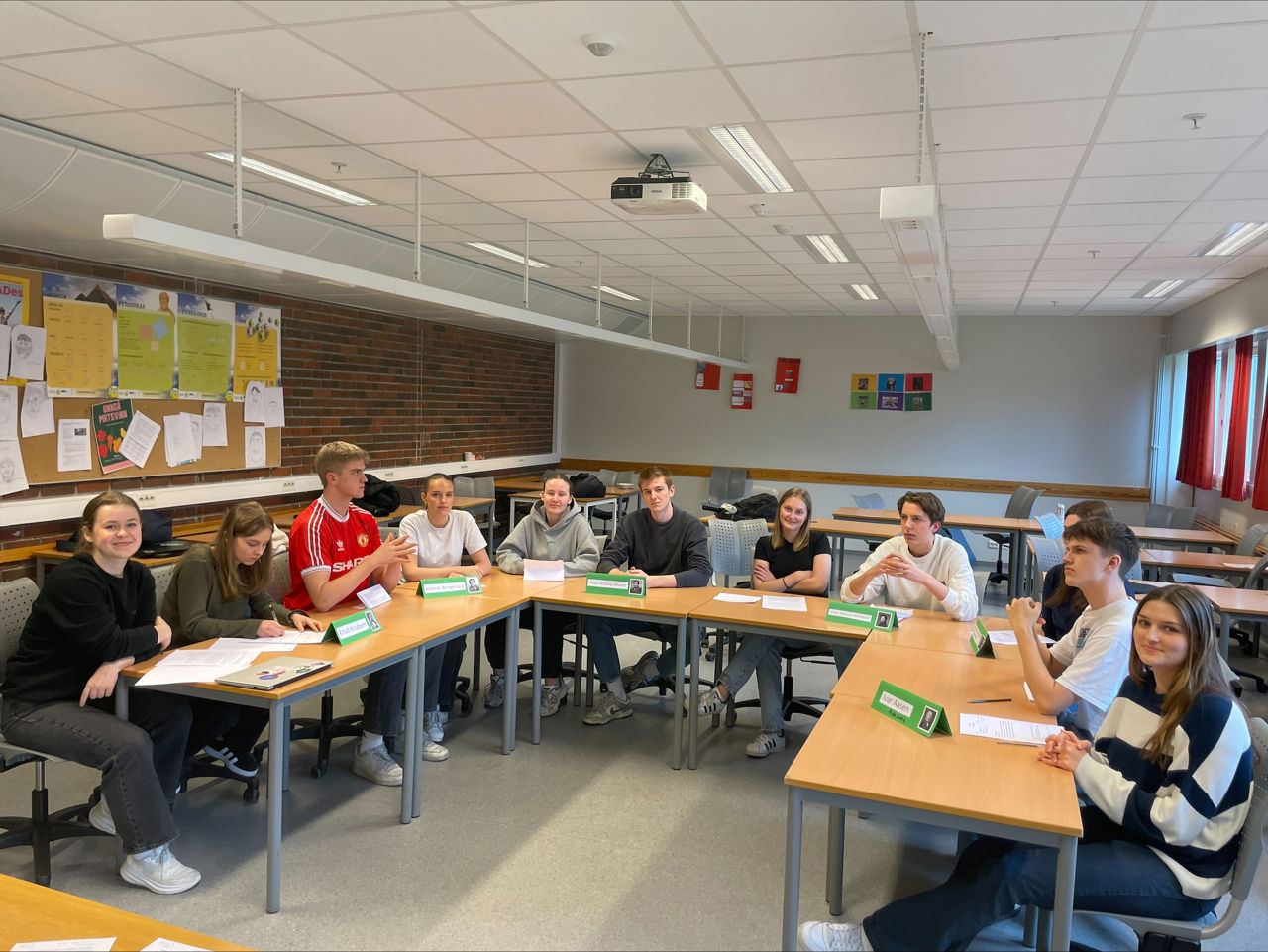 Elevar sit med pultane sine i klasserommet.