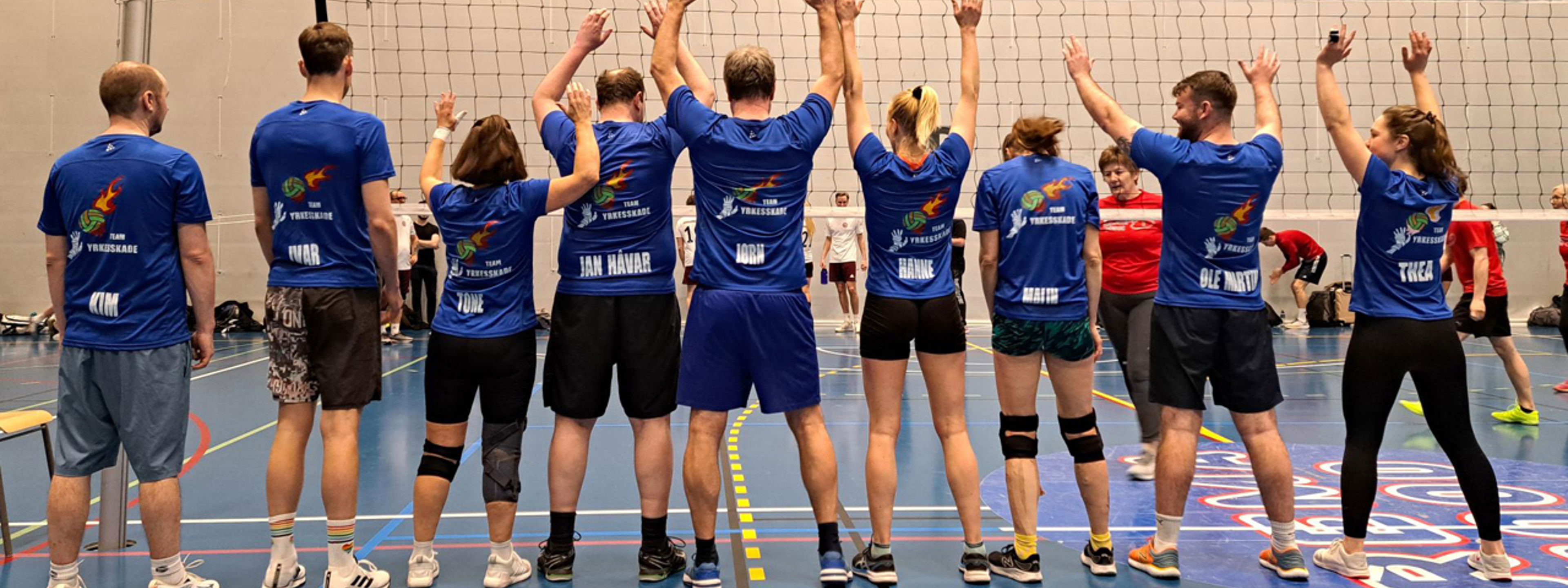 9 volleyball spelarar står med ryggen til og vi ser like drakter.